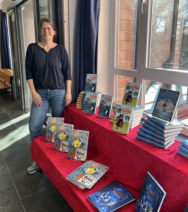 Das Foto zeigt die Kinderbuchautorin Frau Frixe vor ihren Büchern.