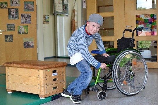 Schüler traniert das sichere Ein- und Aussteigen aus dem Rollstuhl.
