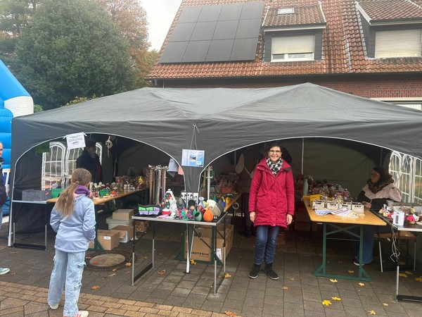 Das Bild zeigt ein Mitglied des Fördervereins vor dem Verkaufsstand.