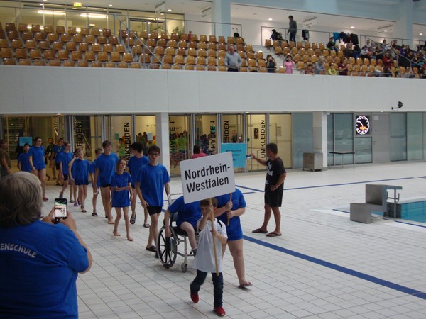 Ein Foto zeigt den Einzug der Athleten der Brückenschule in die große Schwimmhalle.