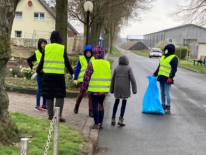 Das Bild zeigt Brückenschüler:innen beim Einsammeln vom Müll in Maria Veen.