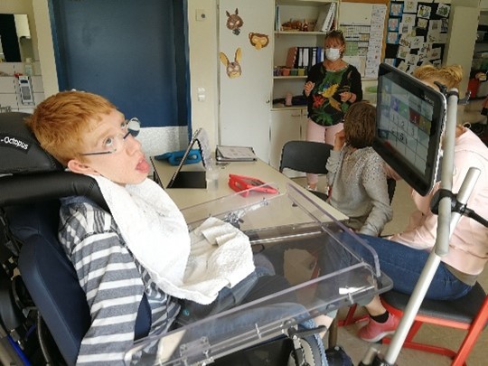 Auf einem Foto sieht man Justus, der mithilfe eines Sprachcomputers mit Augensteuerung kommuniziert.