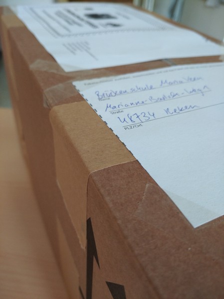 Auf dem Bild sieht man ein Paket mit gesammelten Handys, das an missio e.V. verschickt wird.