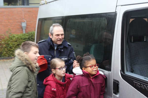 Ein Foto demonstriert Herr Klinger von der Kreispolizei Borken einigen Schüler:innen was "Toter Winkel" bedeutet.