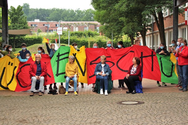 Das Bild zeigt die vier Kolleg:innen auf ihren Ehrenplätzen bei der Abschiedsfeier auf dem Schulhof.