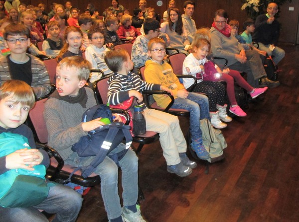 Ein Foto zeigt die Schüler:innen als Zuschauer bei der Aufführung des Theaterstücks "Emil und die Detektive".