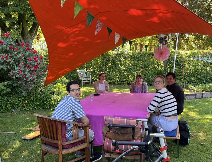 Das Foto zeigt die Schüler:innen  und eine Lehrkraft beim Frühstück im Garten.