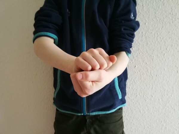 Auf dem Foto sieht man eine nicht elektronische Kommunikationshilfe- eine Gebärde.